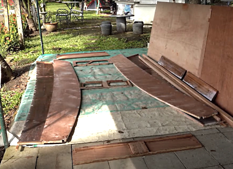 Disassembled parts laid out in correct order to be glued building a plywood sailboat in the Philippines